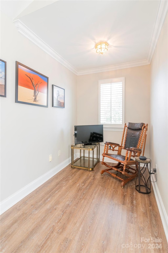 sitting room featuring light wood-type flooring and crown molding