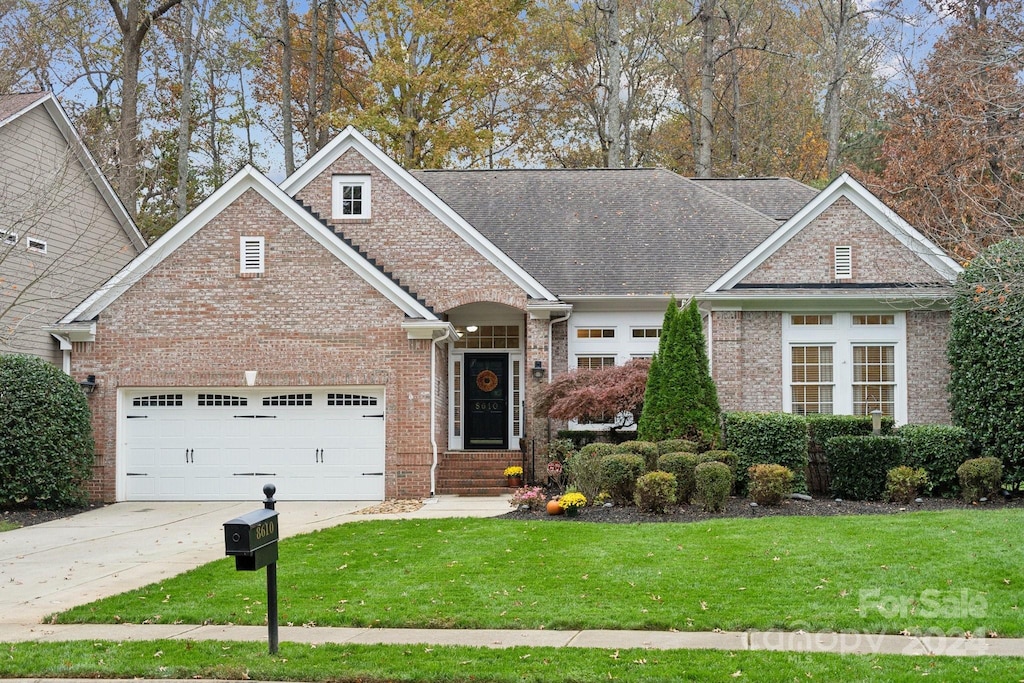 view of front of house with a garage and a front lawn