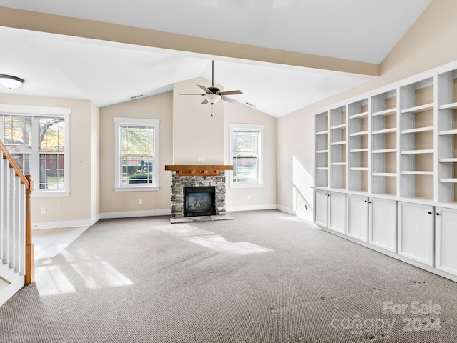 unfurnished living room featuring light carpet, vaulted ceiling with beams, a stone fireplace, and ceiling fan