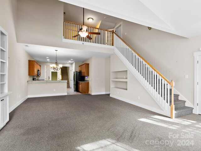 60 Westfield Way, Candler, NC 28715 - unfurnished living room featuring carpet floors, stairway, a chandelier, baseboards, and a towering ceiling
