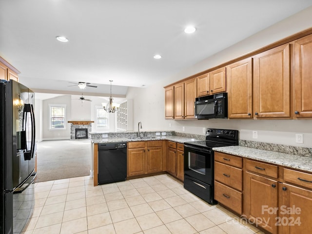 kitchen featuring black appliances, ceiling fan with notable chandelier, light colored carpet, sink, and light stone counters