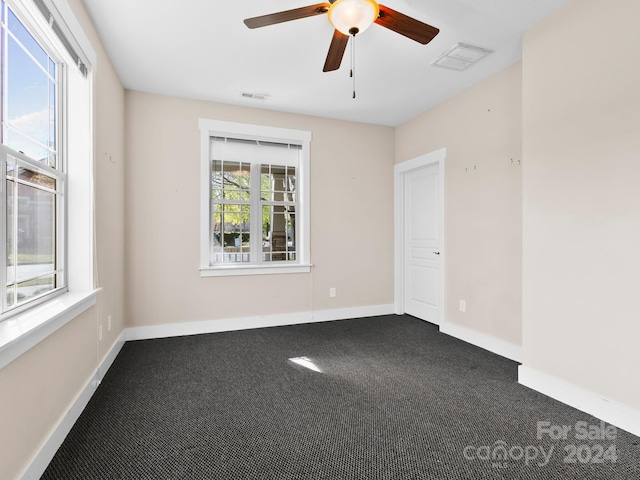 carpeted spare room featuring ceiling fan