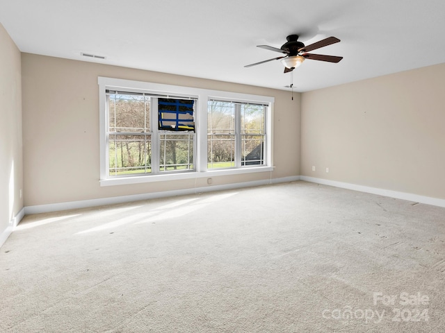 unfurnished room with carpet flooring, ceiling fan, and a wealth of natural light