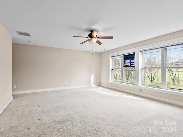 carpeted spare room featuring ceiling fan