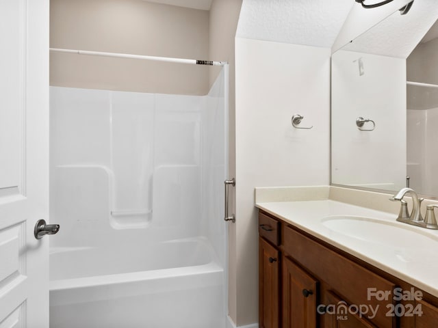 bathroom with vanity, a textured ceiling, and bathing tub / shower combination