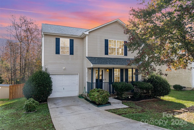 view of front of house featuring a porch, a garage, and a yard