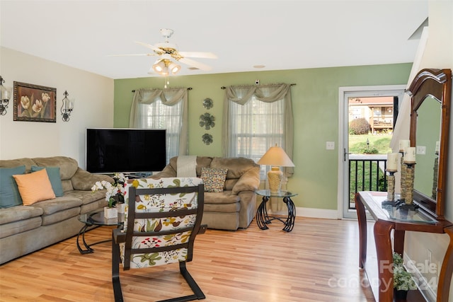 living room featuring ceiling fan, plenty of natural light, and light hardwood / wood-style floors