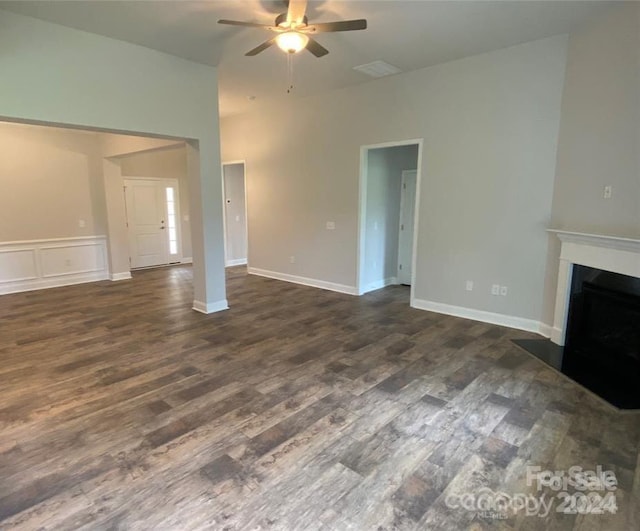 unfurnished living room with ceiling fan and dark wood-type flooring