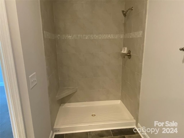 bathroom featuring tile patterned flooring and tiled shower