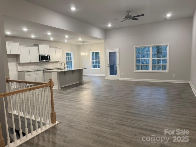 living room featuring dark wood-type flooring and ceiling fan