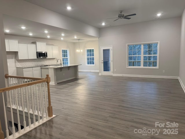 living room with ceiling fan and dark hardwood / wood-style floors