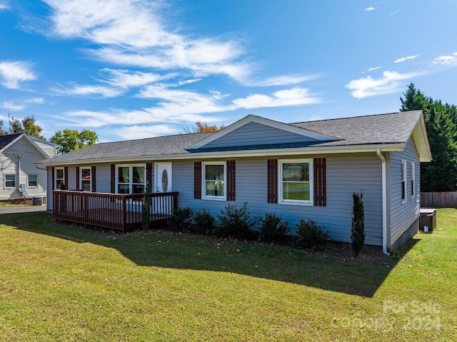 single story home featuring a front lawn and a wooden deck