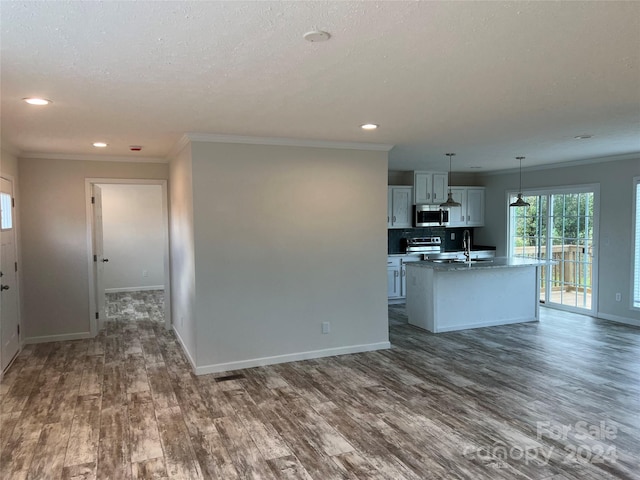 kitchen featuring stainless steel appliances, sink, decorative light fixtures, dark hardwood / wood-style floors, and an island with sink