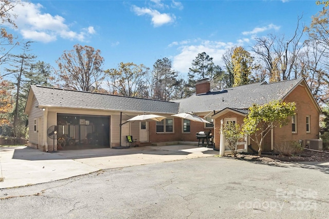 single story home featuring a garage and central AC unit