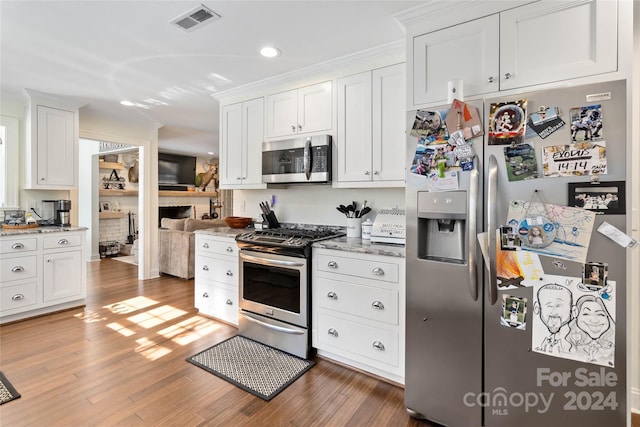 kitchen with white cabinets, light stone countertops, stainless steel appliances, and dark hardwood / wood-style floors