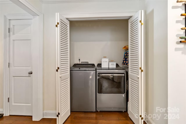 clothes washing area with wood-type flooring, independent washer and dryer, and ornamental molding