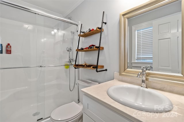 bathroom featuring vanity, toilet, a shower with shower door, and crown molding