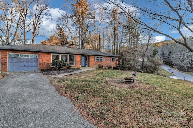 ranch-style home with a mountain view, a garage, and a front lawn