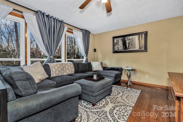 living room featuring ceiling fan, dark hardwood / wood-style flooring, and a textured ceiling