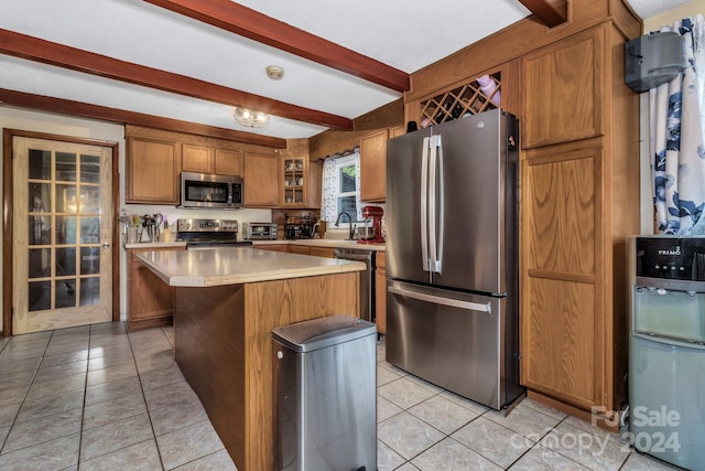 kitchen featuring beam ceiling, a center island, sink, stainless steel appliances, and light tile patterned floors