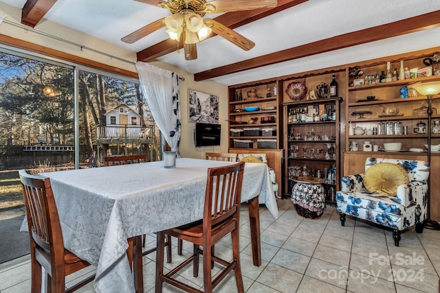 tiled dining room with beam ceiling and ceiling fan