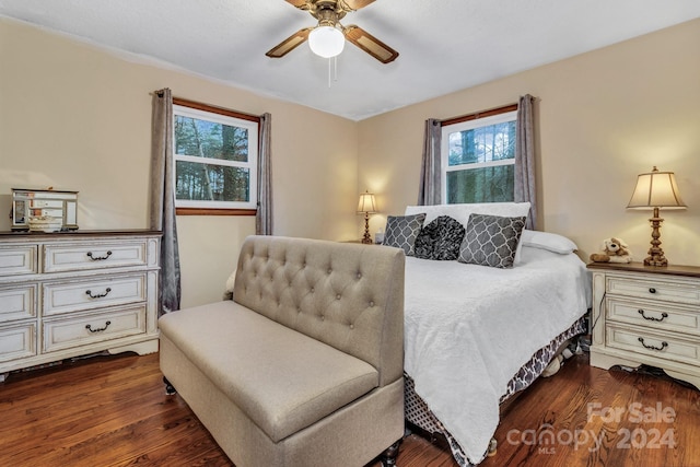 bedroom with ceiling fan, dark hardwood / wood-style flooring, and multiple windows