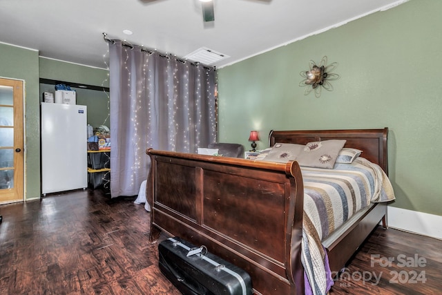 bedroom with dark hardwood / wood-style flooring, white refrigerator, and ceiling fan