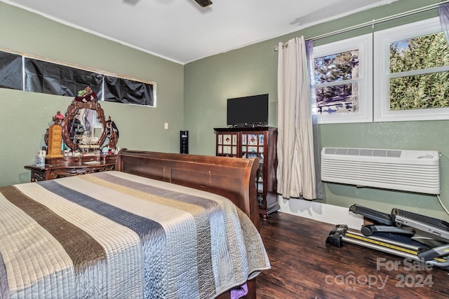 bedroom with a wall unit AC, ceiling fan, and dark wood-type flooring