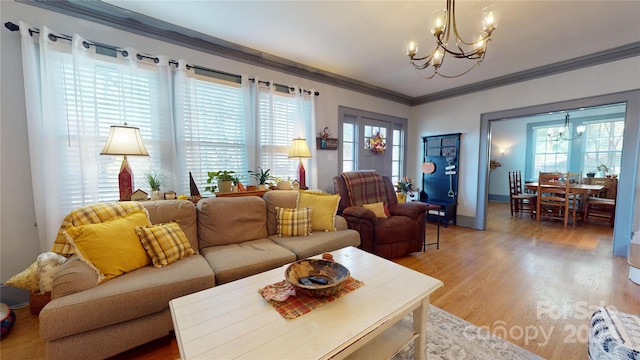 living room featuring crown molding, wood-type flooring, and an inviting chandelier