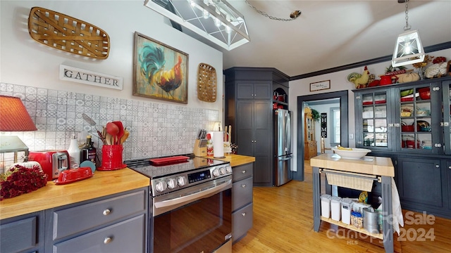 kitchen with stainless steel appliances, pendant lighting, light wood-type flooring, tile walls, and ornamental molding