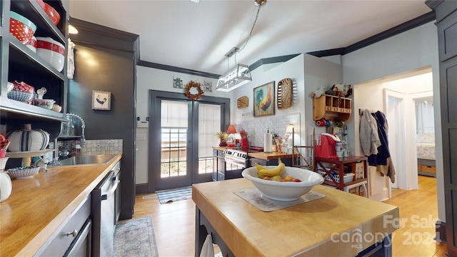 kitchen featuring pendant lighting, stainless steel appliances, light hardwood / wood-style flooring, and sink