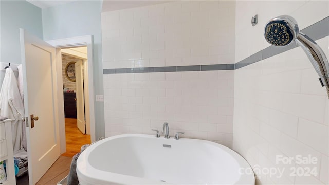 bathroom with hardwood / wood-style floors and a tub