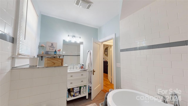 bathroom featuring vanity, tile patterned floors, and a bathing tub