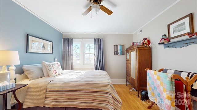 bedroom with ceiling fan, ornamental molding, and light wood-type flooring