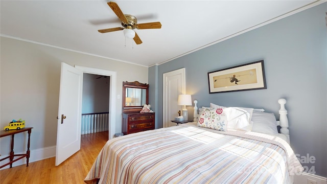 bedroom featuring light wood-type flooring, ceiling fan, and ornamental molding