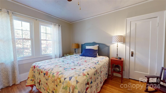 bedroom with wood-type flooring and crown molding