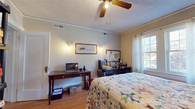 bedroom featuring ceiling fan, crown molding, light hardwood / wood-style floors, and a textured ceiling