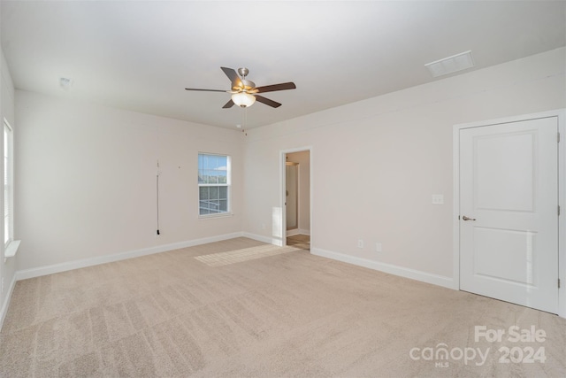 carpeted spare room featuring ceiling fan