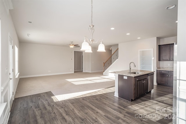 kitchen with dark hardwood / wood-style flooring, dark brown cabinetry, sink, and an island with sink