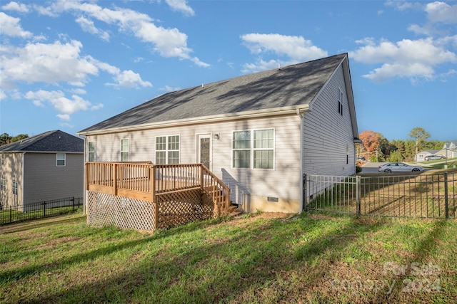 rear view of property featuring a deck and a lawn