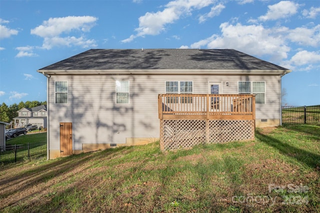 rear view of property with a lawn and a wooden deck