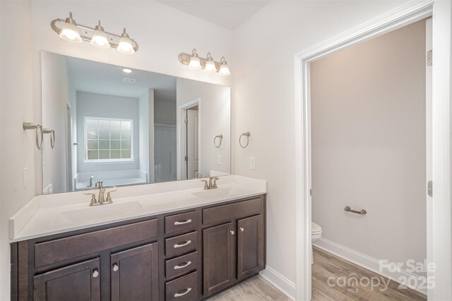 159 Rubys Way Unit 35, Oakboro, NC 28129 - full bathroom featuring toilet, wood finished floors, double vanity, baseboards, and a tub to relax in