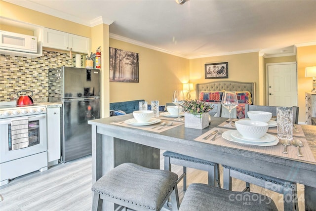 kitchen featuring decorative backsplash, ornamental molding, white appliances, white cabinets, and light hardwood / wood-style floors