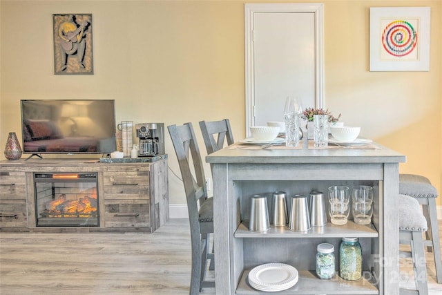 dining space featuring a fireplace and light hardwood / wood-style floors