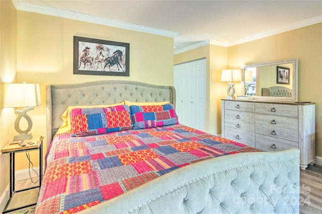 bedroom featuring wood-type flooring, ornamental molding, and a closet