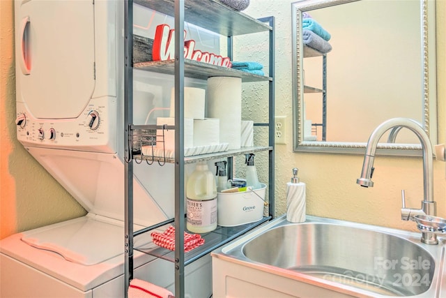 clothes washing area with stacked washer / dryer and sink