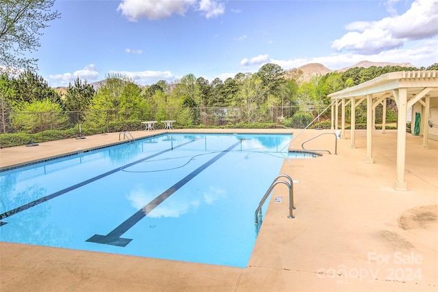 view of pool featuring a patio area and a mountain view