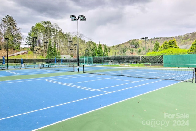 view of sport court featuring basketball hoop and a mountain view