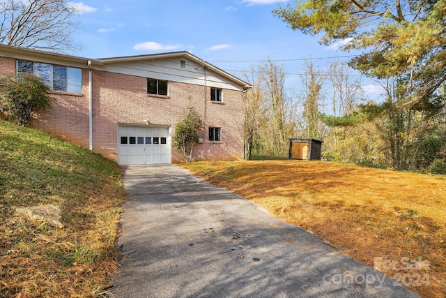 view of property exterior with a storage unit and a garage