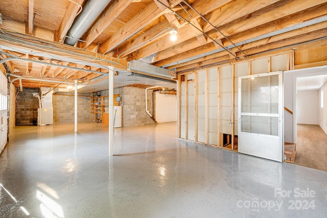 basement with heating unit and brick wall